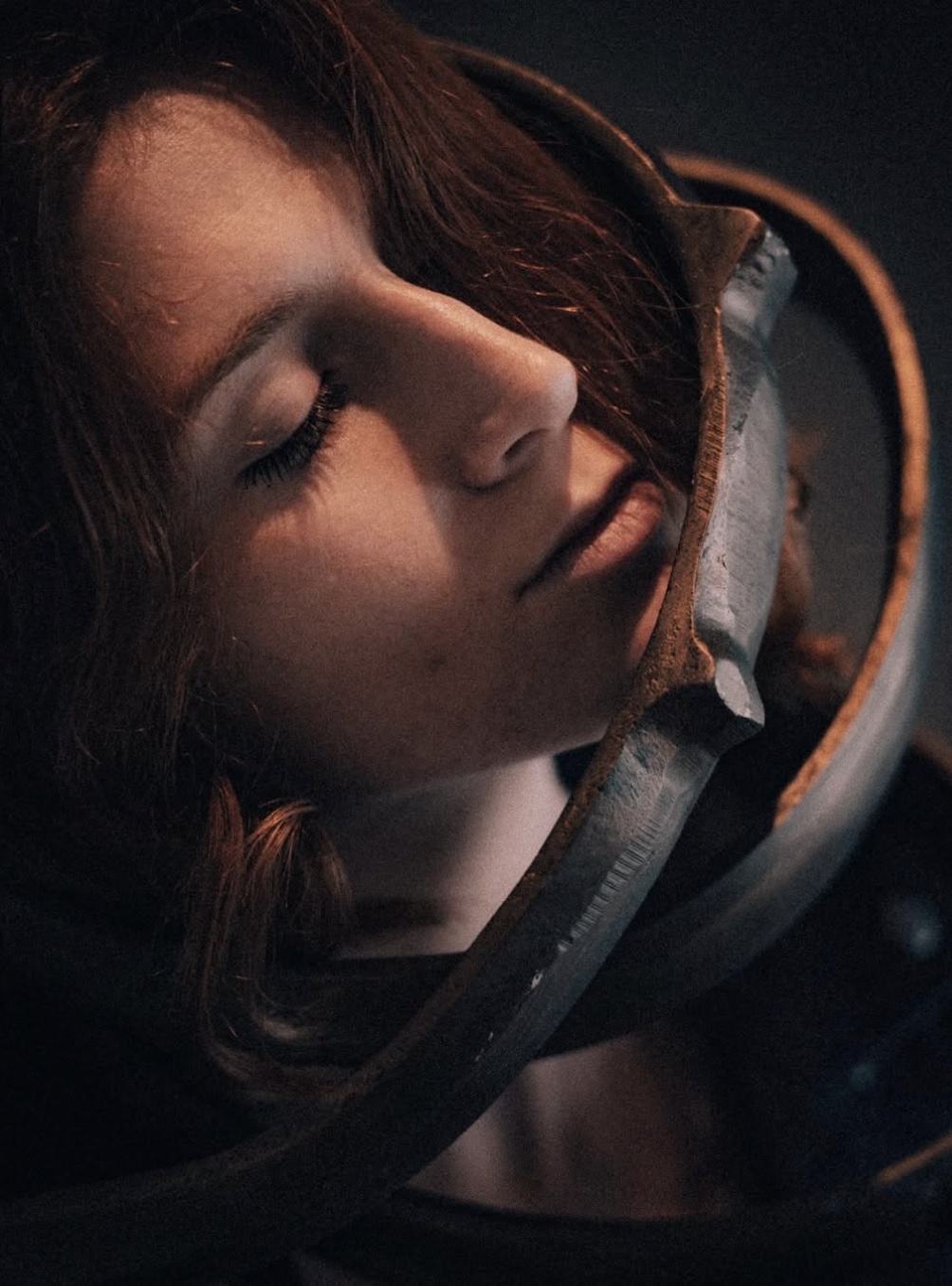 Warm-toned portrait of a woman resting against a mirror